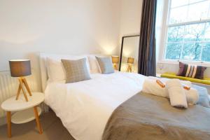 a bedroom with a large white bed and a window at JOIVY Modern City Centre Flat next to Calton Hill in Edinburgh