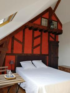 a bedroom with a white bed and a red wall at Les longères de keridy in Brech