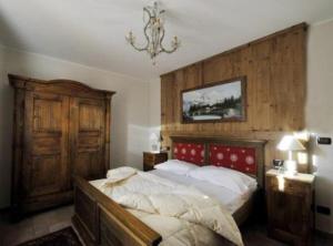 1 dormitorio con cama y lámpara de araña en Au Petit Chevrot en Aosta