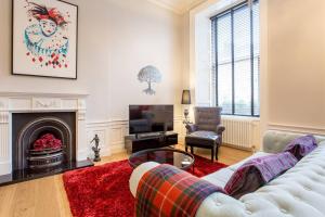 un soggiorno con divano bianco e camino di ALTIDO Luxury Retreat in the City Centre for a Great Price a Edimburgo
