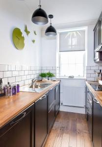 une cuisine avec un évier et un plan de travail en bois dans l'établissement JOIVY Charming Nest for Two with Castle View, à Édimbourg