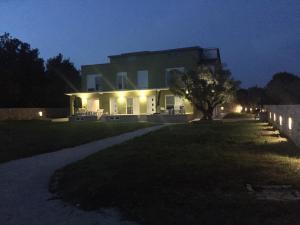 una casa por la noche con un árbol delante de ella en Apartments Nogic en Peroj