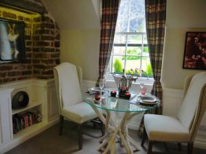 une salle à manger avec une table en verre et deux chaises dans l'établissement JOIVY Charming Nest for Two with Castle View, à Édimbourg 7 autres photos