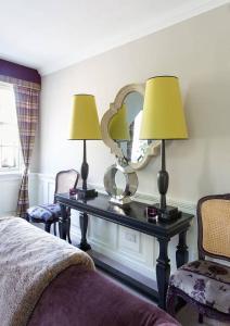 エディンバラにあるJOIVY The Wee Palace by Castleのベッドルーム(ランプ2つと鏡付きのテーブル付)