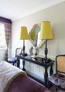 une chambre avec une table avec deux lampes et un miroir dans l'établissement JOIVY Charming Nest for Two with Castle View, à Édimbourg