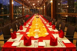 uma mesa longa com uma toalha de mesa vermelha e amarela em Shenzhen Baohengda International Hotel em Longgang