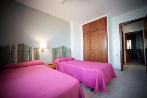 two beds in a room with pink sheets at Apartamentos Florida II in Peñíscola +95 photos