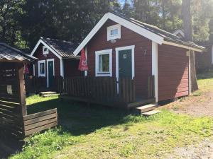 una pequeña casa con una valla en un patio en Stockholm Ängby Camping en Estocolmo