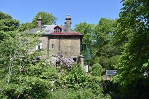 ein altes Backsteinhaus mit rotem Dach in der Unterkunft Apartment close to Pavilion gardens in Buxton