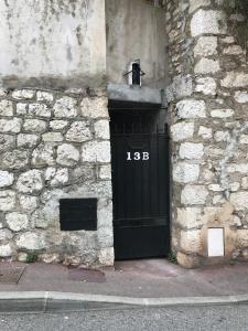 een zwarte deur aan de zijkant van een stenen gebouw bij Apartment "13B" near Monaco in Beausoleil