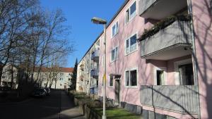ein rosafarbenes Gebäude an der Straßenseite in der Unterkunft Monteurzimmer - Messe Nord in Hannover