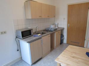 eine kleine Küche mit Mikrowelle und Spüle in der Unterkunft Monteurzimmer - Messe Nord in Hannover