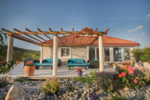 a patio with a wooden pergola and blue furniture at Villa Red Hacienda with Pool in Vodice