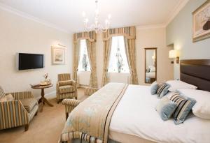 a bedroom with a large bed and a chandelier at The George Hotel in Penrith