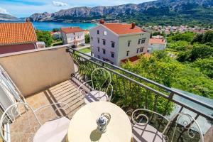 a balcony with a table and a view of a city at Apartments Patricia in Baška