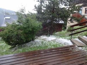 eine Holzbank im Gras neben einem Zaun in der Unterkunft 8 rue du bac in Font-Romeu