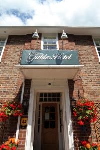 a brick building with a sign above a door at The Gables Hotel in Gretna Green