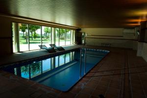 una piscina en un edificio con una ventana grande en La Noguera Camping, en Sant Llorenç de Montgai