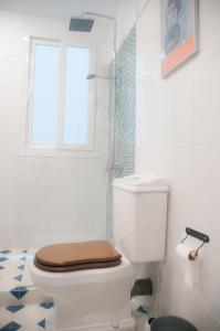 a bathroom with a toilet with a window and a shower at Sancha de Lara in Málaga