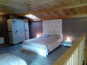 GémozacにあるGîte familial -- Les KIWISの木製の天井が特徴のベッドルーム1室(大型ベッド1台付)