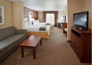 a hotel room with a bed and a flat screen tv at Holiday Inn Express Hotel & Suites Willows, an IHG Hotel in Willows