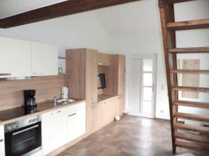 a kitchen with white cabinets and a stove top oven at Ferienwohnungen Am Alten Backhaus in Großkoschen +39 photos