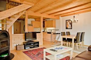 eine Küche und ein Wohnzimmer mit einem Tisch und einem Herd in der Unterkunft Apartment Kiwi rechts - GRIWA RENT AG in Grindelwald