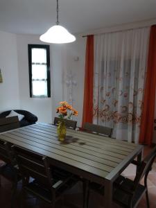 a dining room table with a vase of flowers on it at Villetta al mare in Marsala