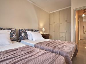 a bedroom with two beds and a cabinet at Giovanna's Lux Apartment in Zakynthos