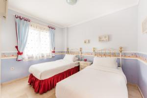 two beds in a room with blue walls and a window at Puerto Bañus - Casa Pietro in Marbella