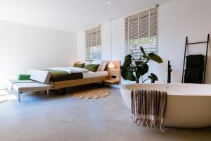 内斯LoftNes的带浴缸、床和沙发的浴室