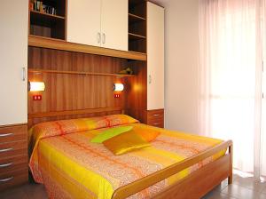 a bedroom with a bed with a wooden headboard at Gabbiano Atlante in Bibione