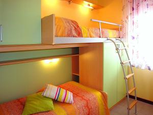 a bedroom with two bunk beds and a ladder at Gabbiano Atlante in Bibione