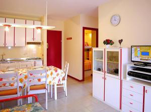 a kitchen and dining room with a table and a kitchen and a room at Gabbiano Atlante in Bibione +9 photos