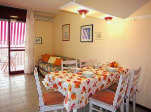 a dining room with a table and a couch at Gabbiano Atlante in Bibione