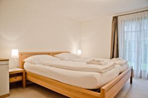 Cama grande en habitación con ventana en Apartment Delta - GRIWA RENT AG en Grindelwald