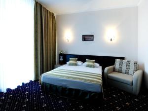 ein Hotelzimmer mit einem Bett und einem Stuhl in der Unterkunft Manhattan Hotel & Restaurant in Chişinău + 103 Fotos