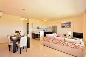 a living room with a couch and a dining room at Luxury Suites in Stavromenos in Stavromenos