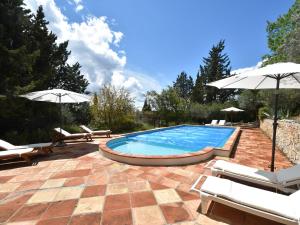 una piscina con 2 sombrillas y sillas en Farmhouse in Draguignan with terrace, en Draguignan