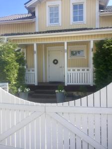 einen weißen Zaun vor einem Haus in der Unterkunft Villa Rhodo in Vantaa