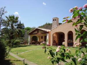 a house with a garden and flowers at Residence Luna Rossa in Costa Rei
