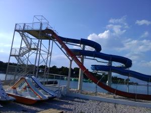 a slide in a water park next to the water at Apartmani Vesna Supetar in Supetar