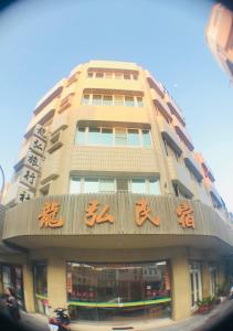 un edificio alto con escritura asiática en él en Long Hong, en Magong