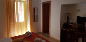una camera con un letto, un tavolo e una finestra di Gli Agrumi Rooms a Trapani