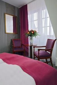 1 Schlafzimmer mit einem Bett, 2 Stühlen und einem Tisch in der Unterkunft Hotel Am Markt in Oebisfelde