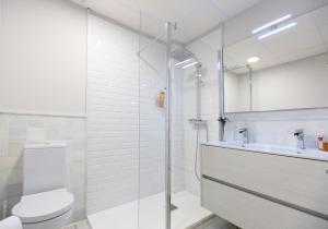 y baño con ducha, aseo y lavamanos. en Apartamento de diseño con jacuzzi privado, en Granada