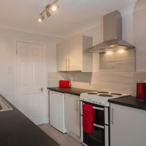 a kitchen with white cabinets and a stove top oven at 33 The Fairway in Newton Ferrers