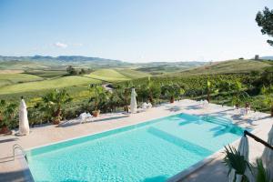 a swimming pool with a view of the rolling hills at Agriturismo Sirignano Wine Resort in Sirignano