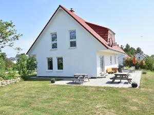 a white house with picnic tables in the yard at Ferienwohnung mit Trampolin in Hornstorf in Hornstorf