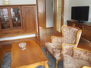uma sala de estar com uma mesa e duas cadeiras e uma televisão em Apartment Nelli em Albstadt